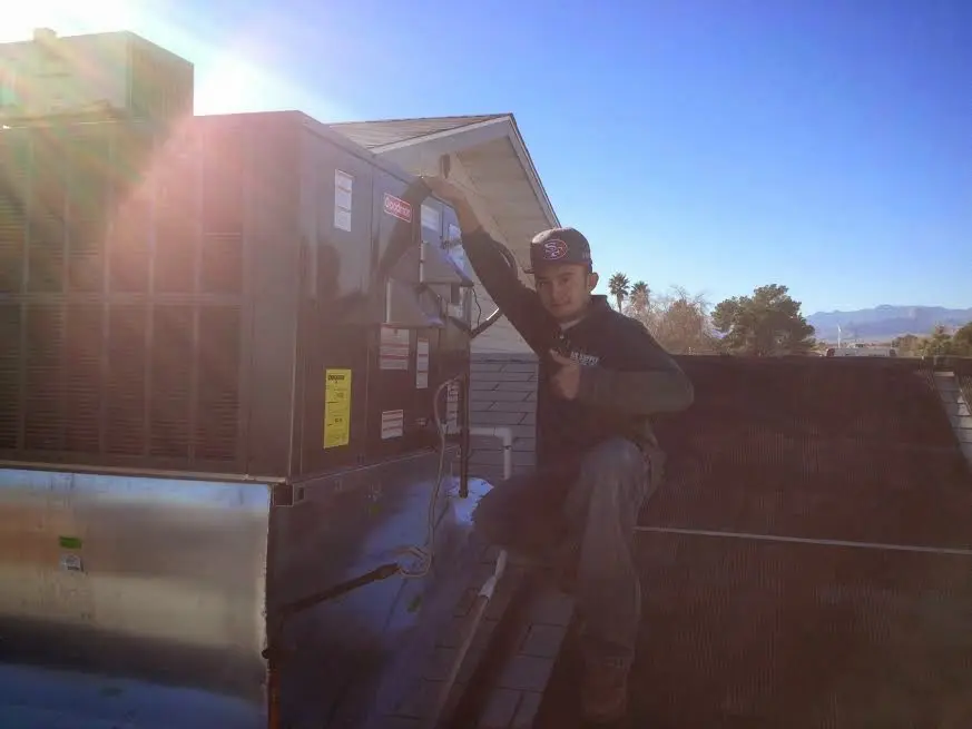 HVAC technician performing Heat Pump Repair on a rooftop unit in Leisure World